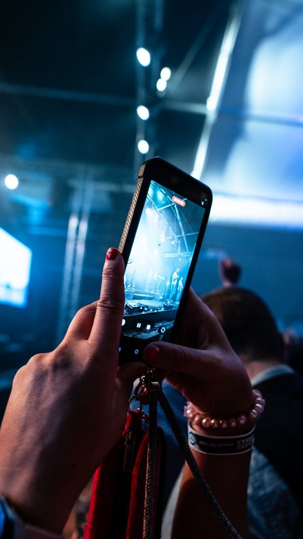 Konzertbesucherin filmt mit dem Smartphone